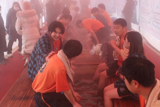 Participants warm their feet in a foot bath after the bare-hand fishing competition at the Hwacheon Sancheoneo Ice Festival in Hwacheon, Gangwon Province. Jan. 12, 2026. AJP Han Jun-gu
