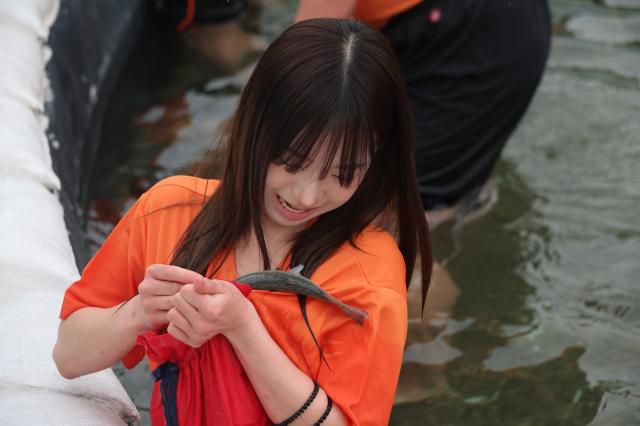 A participant stores a caught mountain trout inside her pocket during the bare-hand fishing competition at the Hwacheon Sancheoneo Ice Festival in Hwacheon, Gangwon Province. Jan. 12, 2026. AJP Han Jun-gu