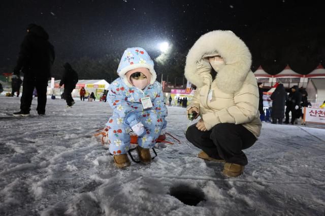 Visitors try ice fishing at night at the Hwacheon Sancheoneo Ice Festival in Hwacheon, Gangwon Province. Jan. 12, 2026. AJP Han Jun-gu