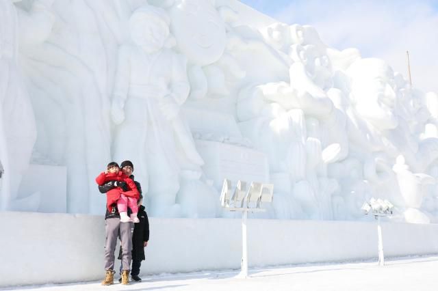 Visitors poses for a photo in front of giant ice sculptures at the Hwacheon Sancheoneo Ice Festival in Hwacheon, Gangwon Province. Jan. 12, 2026. AJP Han Jun-gu