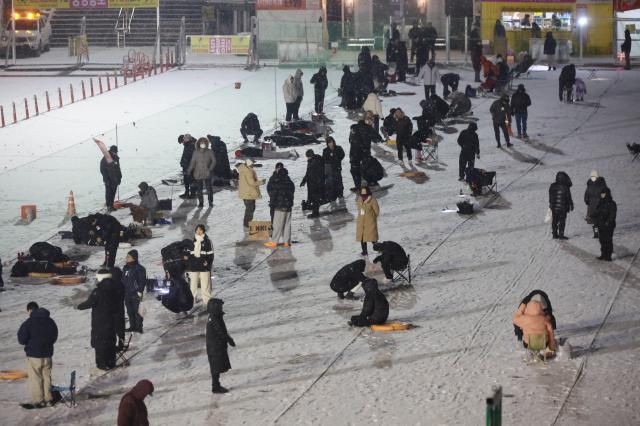 Visitors try ice fishing at night at the Hwacheon Sancheoneo Ice Festival in Hwacheon, Gangwon Province. Jan. 12, 2026. AJP Han Jun-gu