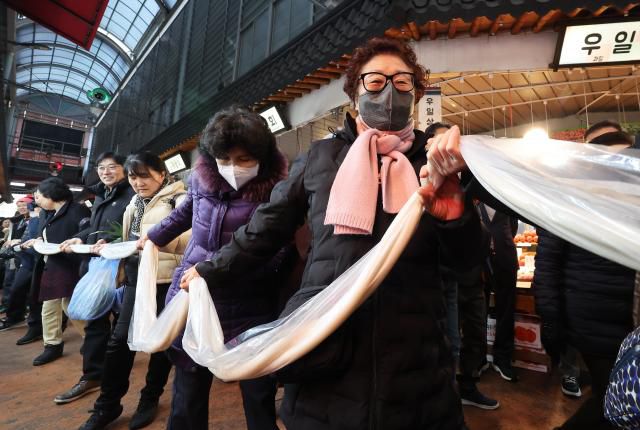 Merchants and citizens make a 180-meter-long garaetteok (Korean rice cake) at a rice cake sharing event held at Motgol Market in Paldal, Suwon, Gyeonggi Province, Jan. 16, 2026.