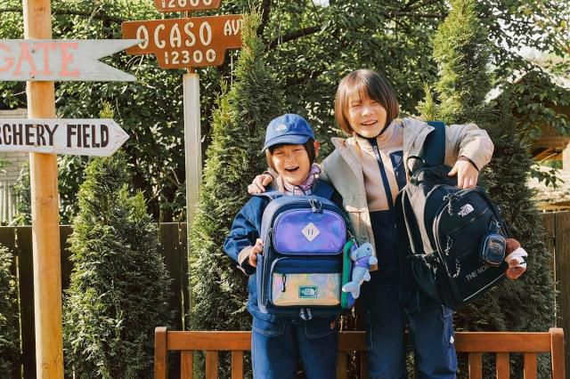 ‘2026 노스페이스 신학기 키즈 가방’을 든 홍보대사 신우(왼쪽)와 이준 [사진=영원아웃도어]