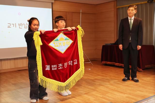Students return the school flag during a farewell ceremony at Gwabeop Elementary School in Sasang-gu, Busan, on Jan. 20. Yonhap