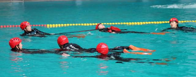 Rescue team members from Incheon Bupyeong Fire Station conduct winter water rescue training at the diving pool of Munhak Park Tae-hwan Swimming Pool in Michuhol-gu, Incheon, on Jan. 21.