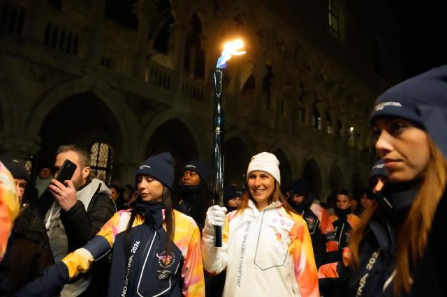 A torchbearer holds an Olympic torch flame in Venice, Italy, Thursday, Jan. 22, 2026, and its journey will conclude in Milan on February 6 for the Winter Olympics opening ceremony. AP Yonhap