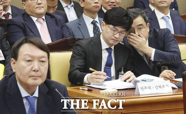 한동훈(가운데) 대검찰청 반부패강력부장이 지난해 10월17일 서울 서초구 대검찰청에서 열린 국회 법제사법위원회의 대검찰청 2019 국정감사에서 백혜련 더불어민주당 의원의 질의에 답변 뒤 조상준(오른쪽) 형사부장과 귀엣말 나누고 있다./뉴시스