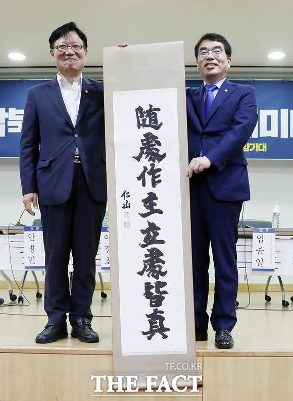 양기대(오른쪽) 더불어민주당 의원이 6일 서울 여의도 국회의원회관에서 열린 포스트코로나 시대의 남북고속철도건설 세미나에서 서호 통일부 차관에게 남북철도 협력 증진을 기원하는 '수처작주 입처개진' 족자를 선물 받은 후 함께 기념촬영을 하고 있다. /뉴시스