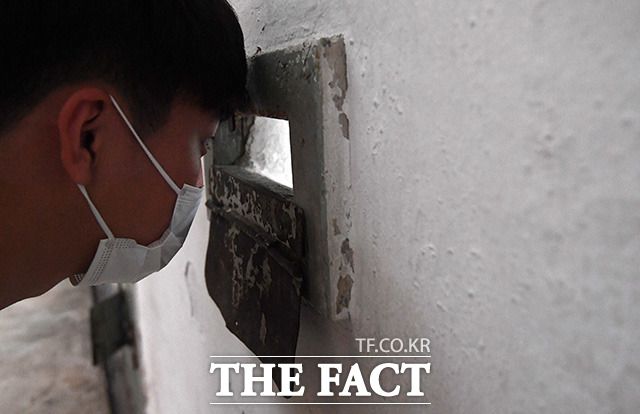 감옥 내부를 들여다보는 관람객.