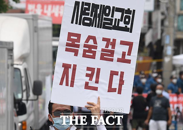 지난 21일 서울 성북구 사랑제일교회 앞에서 전광훈 목사의 변호인단이 기자회견을 하는 가운데, 신도들이 피켓 시위를 하는 모습. /이새롬 기자