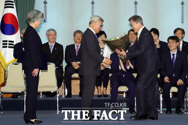 지난 2017년 6월 18일 문재인 대통령이 청와대 본관 충무실에서 강경화 신임 외교부 장관에 임명장을 수여한 뒤 남편 이일병(가운데) 씨에게 꽃다발을 건네고 있다./청와대 제공