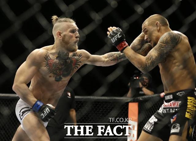 맥그리거(왼쪽)와 포이리에의 지난 2014년 첫 대결 장면. 첫 대결에서는 맥그리거가 1R TKO승을 거뒀으나 재격돌에서는 포이리에가 2라운드 TKO승을 거뒀다./AP.뉴시스