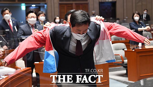 오세훈 국민의힘 서울시장 후보가 지난 3월 24일 서울 여의도 국회에서 열린 국민의힘 의원총회에 참석해 주호영 원내대표의 도움을 받아 당복을 입고 있다. /이새롬 기자