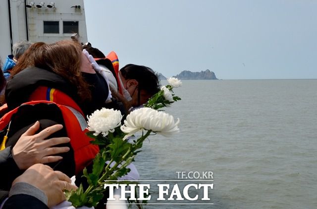 세월호 참사 7주기인 16일 오전 희생자 가족들이 전남 진도군 동거차도 인근 사고 해역을 찾아 바다를 향해 국화를 던지고 있다. /뉴시스