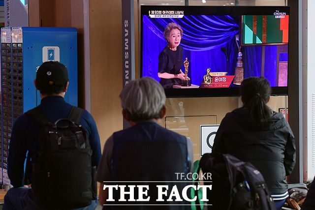26일 오전 서울 용산구 서울역 대합실에서 시민들이 미국 LA에서 열린 제93회 아카데미 시상식에서 여우조연상을 수상한 배우 윤여정의 모습을 시청하고 있다. /이선화 기자