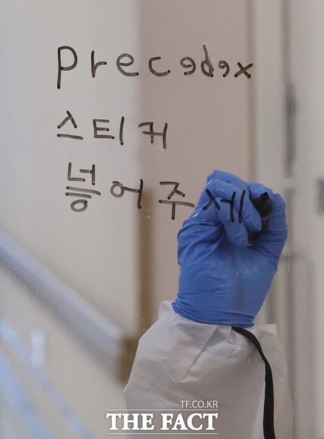 문재인 대통령이 24일 오후 이대서울병원을 방문한 가운데 코로나19에 감염된 환자가 입원한 병동에서 근무 중인 간호사가 필요 사항을 메모로 전달하고 있다. /뉴시스