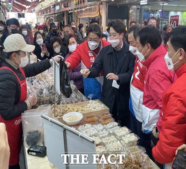 국민의힘 이준석 대표가 김해 외동전통시장 한 상인에게 한과를 구입하고 있다./김해=강보금 기자