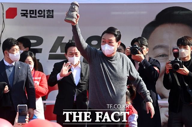 윤석열 국민의힘 대선 후보가 8일 제주 제주시 동문시장 인근에서 열린 유세에서 한 아이로부터 받은 돌하르방을 들어 보이고 있다. /뉴시스