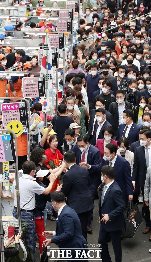 윤석열 대통령이 26일 오후 대구 중구 서문시장을 방문해 장바구니를 들고 상인 및 시민들과 인사하고 있다. /뉴시스