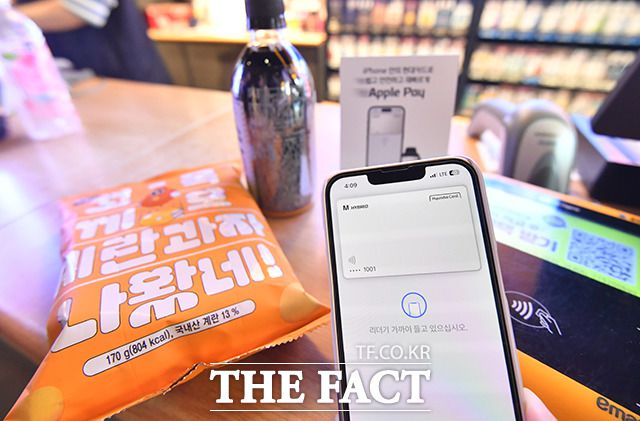 애플의 근거리무선통신(NFC) 결제 서비스 '애플페이'가 국내에 출시된 첫날인 21일 오후 서울 용산구의 한 편의점에서 시민이 애플페이로 결제하고 있다.