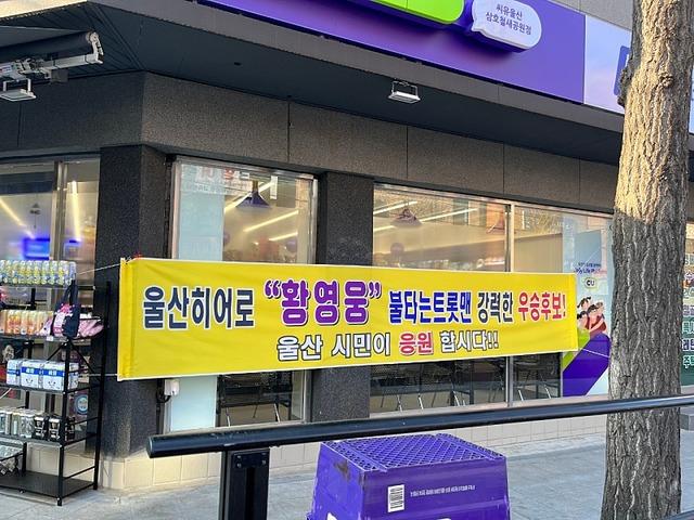 황영웅은 '불트' 출연을 통해 팬덤을 형성해 팬들의 강력한 지지를 받았으나 과거사 논란이 조명되면서 결승 2라운드 직전 하차했다. 사진은 지난달 27일 황영웅의 한 팬이 울산의 한 편의점 앞에 걸어 놓은 현수막의 모습. /온라인 커뮤니티 캡처