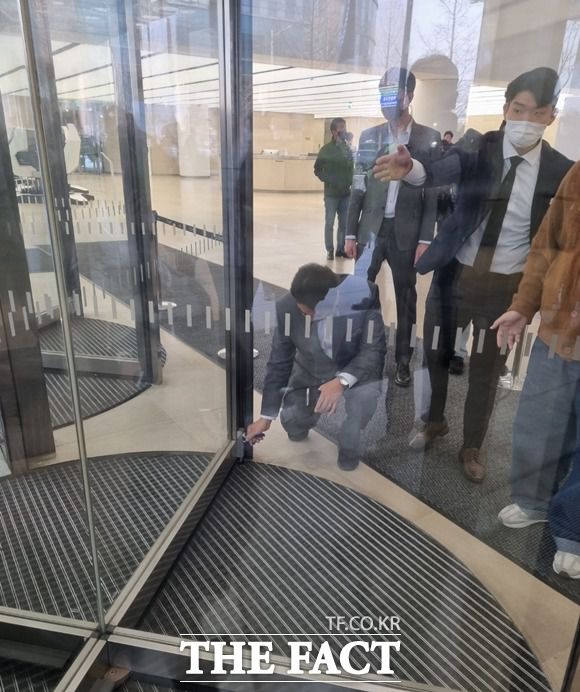 한국타이어 직원이 노조 조합원들로 구성된 주주의 출입을 막기 위해 회전문을 걸어 잠그고 있다. /이성락 기자