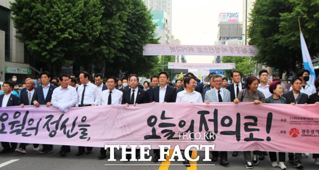 강기정 광주시장과 김병민 국민의힘 최고위원 등이 시민단체 회원들과 함께 '오월의 정신을 오늘의 정의로!'라고 쓰인 현수막을 들고 행진하고 있다./ 광주 = 나윤상 기자