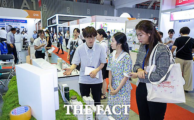 전시회 부스를 찾은 관람객들이 관계자의 설명을 듣고 있다.