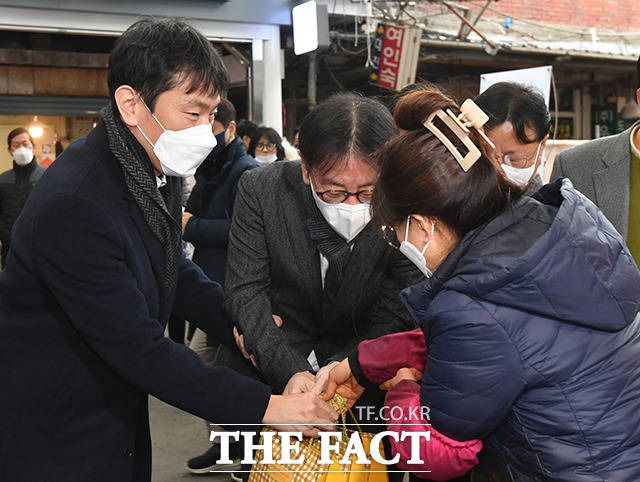 이복현 금융감독원장(왼쪽)과 이재근 KB국민은행장이 지난 1월 서울 영등포구 영등포중앙시장에서 열린 '금융권이 함께하는 설맞이 전통시장 나눔' 행사에 참석해 물건을 구매하고 있다. /박헌우 기자