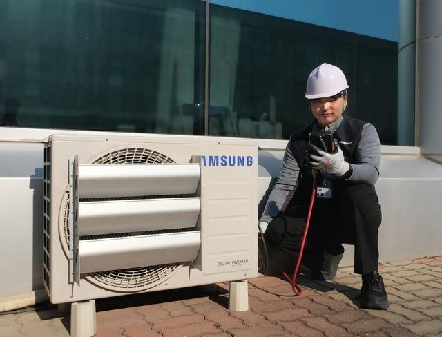 삼성전자서비스 엔지니어가 한여름을 앞두고 에어컨 실외기를 점검하고 있다. /삼성전자