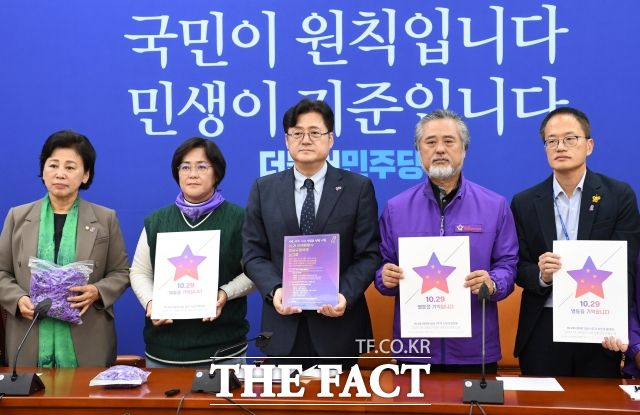 홍익표 더불어민주당 원내대표와 이정민 이태원참사 유가족협의회 운영위원장(왼쪽 두 번째부터) 등 참석자들이 24일 오후 서울 여의도 국회에서 열린 10.29 이태원참사 유가족과 면담에서 이태원참사 1주기 시민추모대회 포스터를 들고 기념촬영을 하고 있다. /남용희 기자