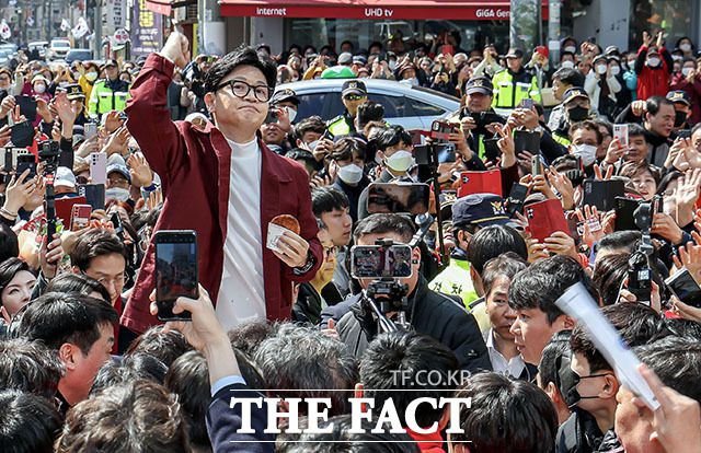 14일 부산 사하구 괴정골목시장을 방문, 호떡을 들고 시민들에게 인사하는 한동훈 국민의힘 비상대책위원장. /뉴시스