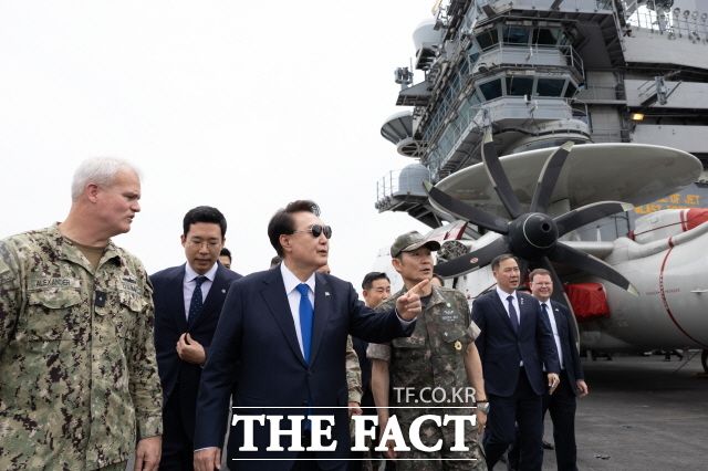 윤석열 대통령이 25일 오후 부산 해군작전기지에 정박 중인 미국 시어도어 루즈벨트 항공모함을 방문, 크리스토퍼 알렉산더 9항모강습단장, 양용모 해군참모총장과 함께 루즈벨트함 비행갑판을 시찰하고 있다. 윤 대통령은 한미 장병들을 만나 루즈벨트함의 국내 입항에 대해 "미국의 철동같은 방위공약을 상징한다"고 강조했다. /대통령실 제공