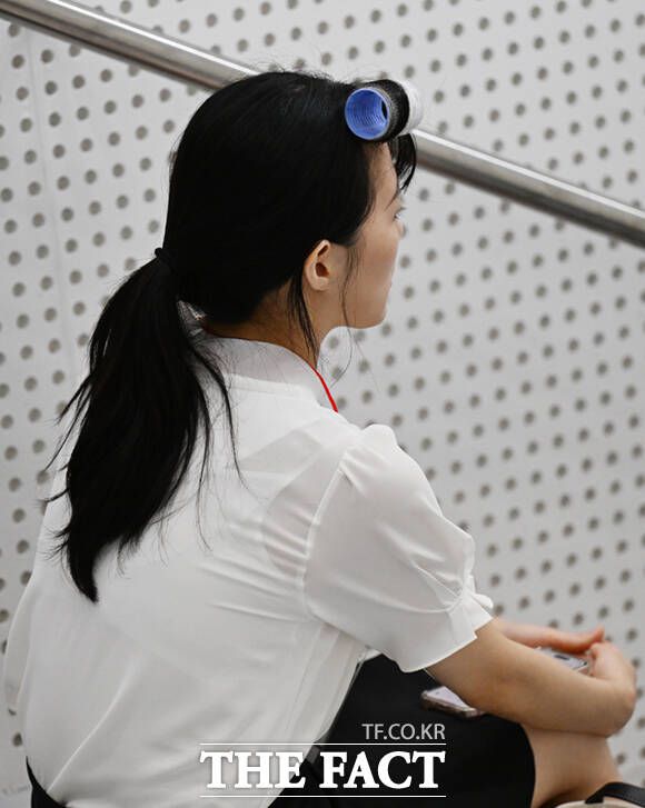 현장면접을 앞둔 한 취업준비생이 앞머리에 헤어롤이 한 채 생각에 잠고 있다.