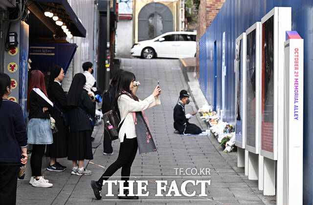 '10.29 기억과 안전의 길'을 찾은 시민들이 새로 설치된 빌보드를 살펴보고 사진찍으며 각자의 방식으로 추모하고 있다.