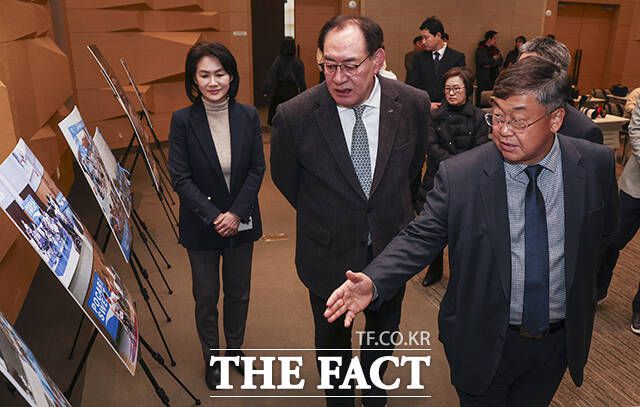 박철호 동아오츠카 대표이사 사장(오른쪽)과 하형주 서울올림픽기념국민체육진흥공단 이사장(가운데)이 업무협약식에 앞서 비인기 스포츠 종목 사진을 살펴보고 있다.