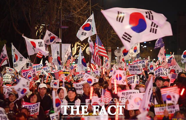 태극기를 들고 탄핵 반대 집회에 참석한 시민들.