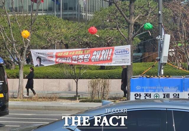 31일 서울 종로구 광화문 인근에 자유민주당 현수막이 설치돼 있다. 한 시민은 낮게 걸린 현수막에 머리가 걸릴 뻔해 허리를 숙이고 지나가는 불편을 겪었다. /광화문=서다빈 기자