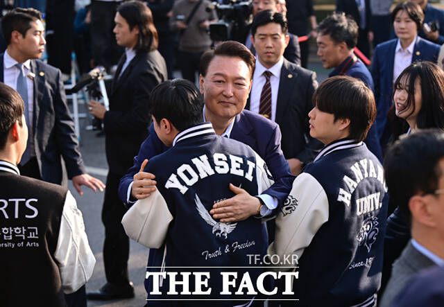 윤석열 전 대통령이 11일 오후 서울 용산구 한남동 관저 정문에서 퇴거하며 배웅나온 학생들과 포옹하고 있다. /이새롬 기자