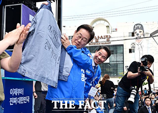 '이제는 진짜 대한민국'이라고 적힌 작업복 전달 받은 이재명 후보.
