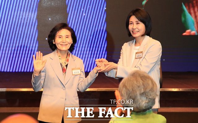 이재명 더불어민주당 대선 후보의 부인 김혜경 여사와 김문수 국민의힘 대선후보의 부인 설난영(왼쪽) 여사가 12일 서울 중구 신라호텔에서 열린 중앙신도회 창립 70주년 기념식에서 손을 맞잡은 모습. /뉴시스