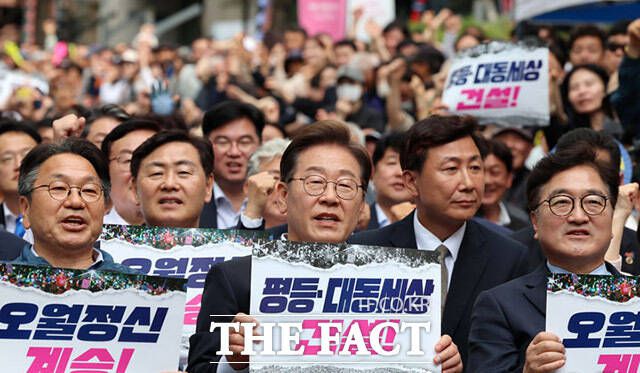 이재명 더불어민주당 대선 후보(가운데)가 17일 오후 광주광역시 동구 금남로에서 열린 5.18 광주민주화운동 45주기 전야제에 참석해 손피켓을 들어보이고 있다. /광주=뉴시스