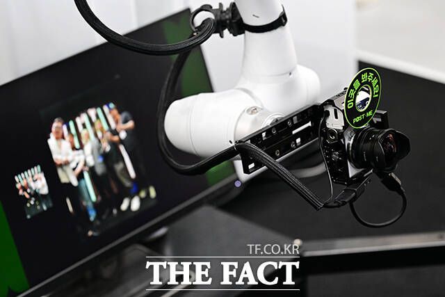'찰칵! 이젠 사진 촬영도 AI가 맡아서' 두산로보틱스 부스를 찾은 관람객이 AI 로봇 스마트 촬영 솔루션을 체험하고 있다.