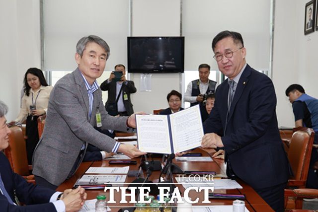 백호 서울교통공사 사장(왼쪽)이 지난달 7일 서울 여의도 국회에서 맹성규 국회 국토교통위원장에게 법정 무임승차 공익서비스 비용에 대한 국비 보전을 촉구하는 공동건의문을 전달하고 있다./서울교통공사