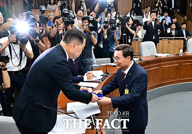 증인선서를 마친 뒤 신성범 위원장에게 선서문 제출하는 이종석 후보자.