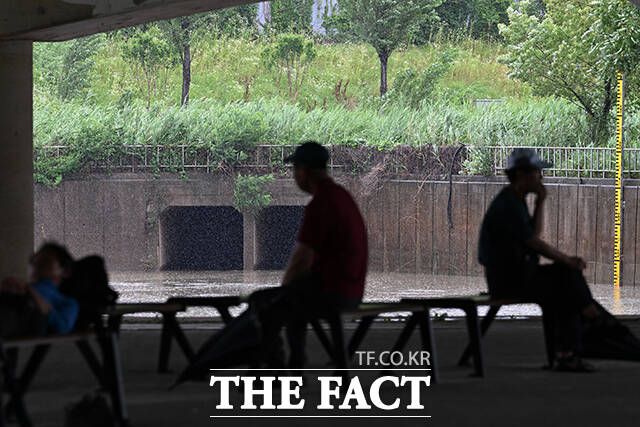 시민들이 양천교 아래에서 비를 피하고 있다.