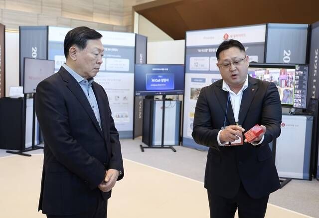 신동빈 롯데그룹 회장(왼쪽)이 지난 1월 서울 송파구 롯데월드타워에서 열린 2025 상반기 VCM에 참석하기 전 AI 과제 쇼케이스를 살펴보며 롯데케미칼의 AI 기반 컬러 예측 시스템에 대한 설명을 듣고 있다. /롯데그룹