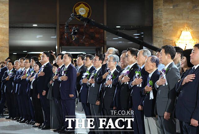 국기에 대한 경례하는 참석자들.