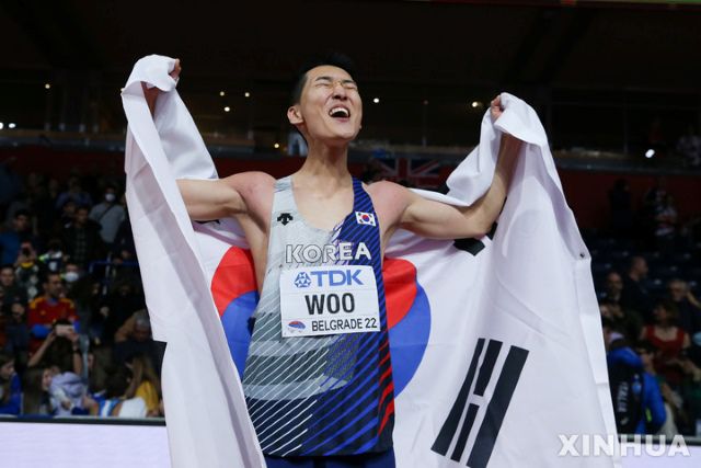 2022 세계실내육상선수권대회 남자 높이뛰기 결선에서 1위를 차지한 뒤 태극기를 몸에 두르고 환호 중인 우상혁. 이제 세계선수권, 아시안게임, 올림픽에서 이런 장면이 다시 연출되기를 바라고 있다. 우상혁의 인생목표인 50cm 클럽에 가입하면 충분히 가능하다. / 신화 뉴시스