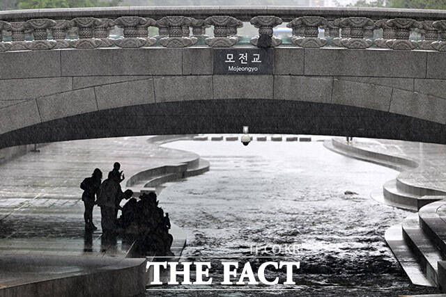 모전교 아래 비를 피하는 시민들.